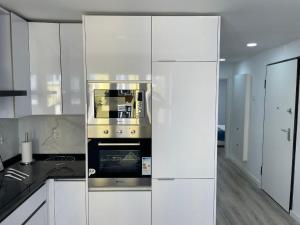 a kitchen with white cabinets and an oven at Mentor Molly in Amadora