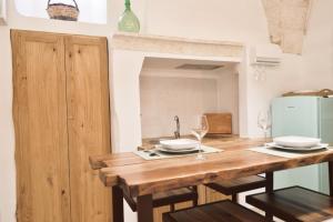 una cucina con tavolo in legno e bicchieri di vino di Civico 60 Apartments a Ceglie Messapica