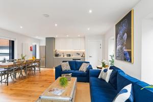 - un salon avec un canapé bleu et une table dans l'établissement Central Richmond 3 Bedroom House, à Richmond upon Thames