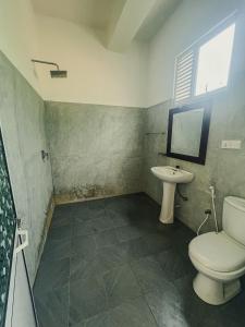 a bathroom with a toilet and a sink at Leyon Paradise Hotel in Unawatuna