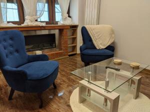 salon z 2 krzesłami i szklanym stołem w obiekcie Ultra-central apartment in the Dauerbach Palace w mieście Timişoara