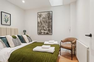 - une chambre avec un grand lit et une couverture verte dans l'établissement Central Richmond 3 Bedroom House, à Richmond upon Thames