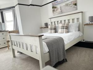a bedroom with a white bed with pillows at The Fishmongers Tavern in Sheringham