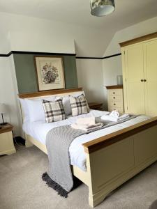 a bedroom with a large bed with white sheets and pillows at The Fishmongers Tavern in Sheringham
