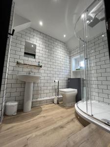 a bathroom with a sink and a toilet and a shower at The Fishmongers Tavern in Sheringham
