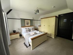 a bedroom with a large bed and yellow cabinets at The Fishmongers Tavern in Sheringham