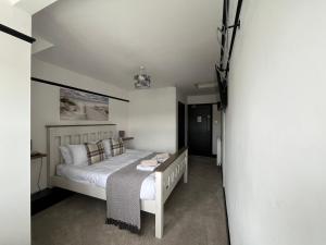 a bedroom with a bed and a tv in it at The Fishmongers Tavern in Sheringham