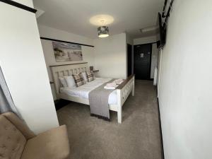 a bedroom with a white bed in a room at The Fishmongers Tavern in Sheringham