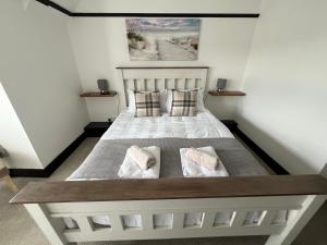 a bedroom with a large bed with two pillows at The Fishmongers Tavern in Sheringham