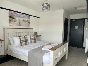 a bedroom with a bed with white sheets and pillows at The Fishmongers Tavern in Sheringham