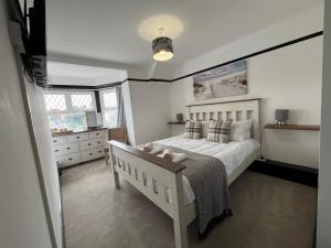 a bedroom with a white bed and a window at The Fishmongers Tavern in Sheringham