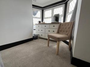 a bedroom with a dresser and a chair in a room at The Fishmongers Tavern in Sheringham