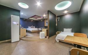 W Hotel في Yangsan: غرفة نوم بسريرين وطاولة وغرفة
