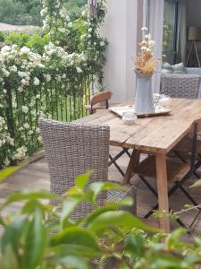 una mesa de madera y sillas en un patio en Magnifique villa de charme avec piscine en Draguignan