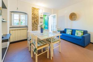 sala de estar con mesa y sofá azul en La Casetta del Casale In Vigna, CinqueTerreCoast, en Casarza Ligure