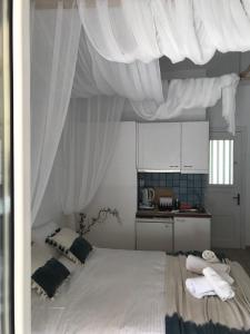 a bedroom with a bed with white curtains over it at Morpheus Rooms in Kini