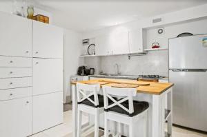 a kitchen with a wooden table and white cabinets at Serene Apartment surrounded by Nature in Sydney
