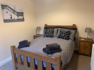 a bedroom with a wooden bed with towels on it at Woodside Retreat with Luxury Hot Tub in Retford