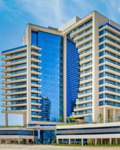 a rendering of a building with blue windows at The First Collection Business Bay in Dubai