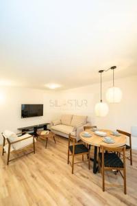 a living room with a table and a couch at Sella Apartamento in Gijón