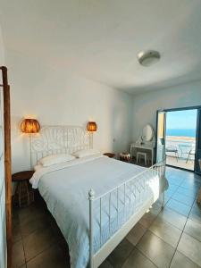 a bedroom with a bed and a view of the ocean at Sunset Paradise Oia in Oia
