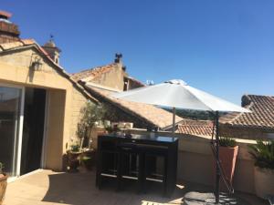 un patio con sombrilla y mesa en Chateauneuf du Pape - Chez Marie-suite loft parentale - Idéale pour 2 adultes - 2 enfants - vue panoramique - terrasse - Jacuzzi en option, en Châteauneuf-du-Pape
