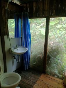 baño con lavabo y aseo y ventana en Puluong homestay nacoLodge, en Làng Chiêu