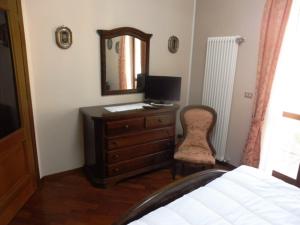 een slaapkamer met een dressoir met een computer en een spiegel bij La Dimora di Nonno Piero in Manta