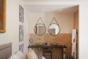 a bathroom with two sinks and two mirrors at Casa del Sole Chambres d'Hotes de Charme in Favone