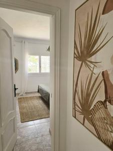 una habitación con un pasillo con una pintura de una planta en la pared en An Oasis For You And Your Loved Ones at Can Rafa, en San Antonio