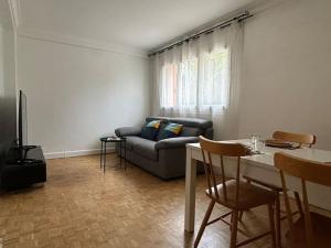 a living room with a couch and a table at Entire home 12 mins to RER A St Germain en Laye in Saint-Germain-en-Laye
