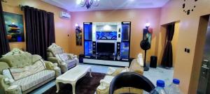 uma sala de estar com uma grande máquina de jogos de vídeo em THE MARBLE ARCH em Uyo