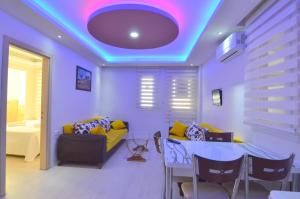 - un salon avec un plafond violet, une table et un canapé dans l'établissement Mykonut Apart Hotel, à Fethiye