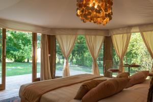 a bedroom with a large bed and a chandelier at Glamping Canonici di San Marco in Mirano