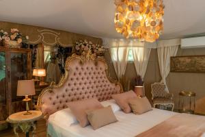 a bedroom with a large bed and a chandelier at Glamping Canonici di San Marco in Mirano