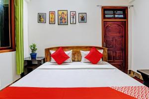 1 dormitorio con 1 cama con almohadas rojas y blancas en OYO Flagship Narangam Homestay, en Darjeeling