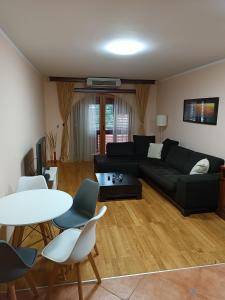 ein Wohnzimmer mit einem schwarzen Sofa und einem Tisch in der Unterkunft Villa Beatrix Budva in Budva