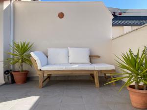 una panca su un patio con due cuscini sopra di Ático duplex Do It Mediterranean a Vinarós