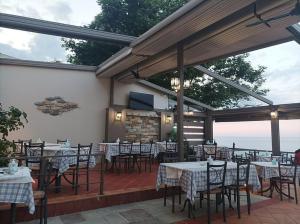 a restaurant with tables and chairs and a television at Ενοικιαζόμενα Δωμάτια "Pelion Plaza" in Agios Ioannis Pelio