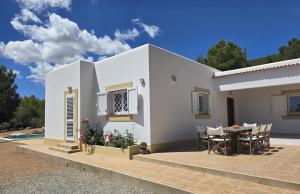 a white house with a table and chairs at An Oasis For You And Your Loved Ones at Can Rafa in San Antonio