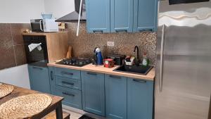 a kitchen with blue cabinets and a stainless steel refrigerator at Apartman Emily in Čavle