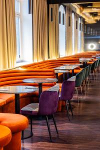 una fila de mesas y sillas en un restaurante en Tribe Riga City Center en Riga