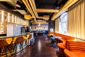 a restaurant with orange chairs and a bar at TRIBE Riga City Centre in Rīga