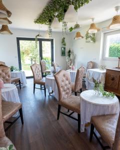 a dining room with white tables and chairs at Basel Airport Stay in Blotzheim