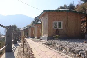 a row of small wooden buildings with a sidewalk at Basera Home stay in Gopeshwar