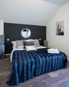 a bedroom with a large bed with a blue blanket at Basel Airport Stay in Blotzheim