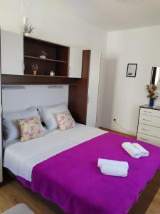 a bedroom with a large bed with a purple blanket at Guesthouse MM in Dubrovnik