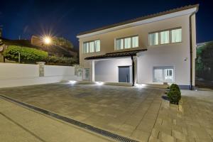 Delux studio apartment Aron with free Parking في بولا: منزل أبيض كبير مع ممر في الليل