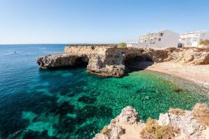 a cave in the water next to a beach at Casa Teo. in Santa Pola