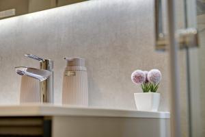 Delux studio apartment Aron with free Parking في بولا: طاولة حمام مع حوض غسيل مع زهور في مزهرية